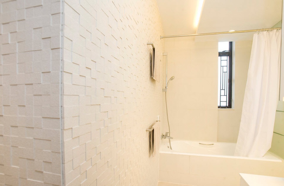 Baltas matētas flīzes uz sienas vannas istabā