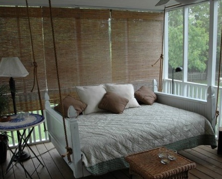 Hängendes Bett mit Armlehnen auf der Veranda