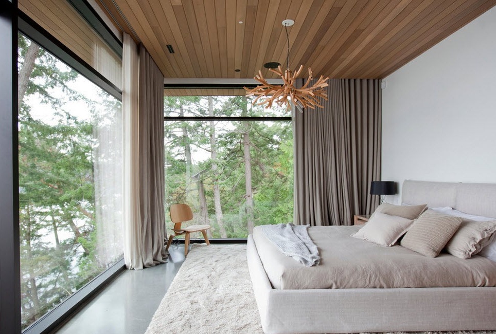 Panoramiczne okna w sypialni i drewniany sufit