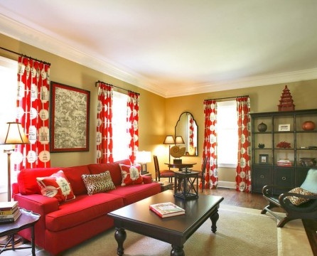 Curtains with round patterns and a red sofa.