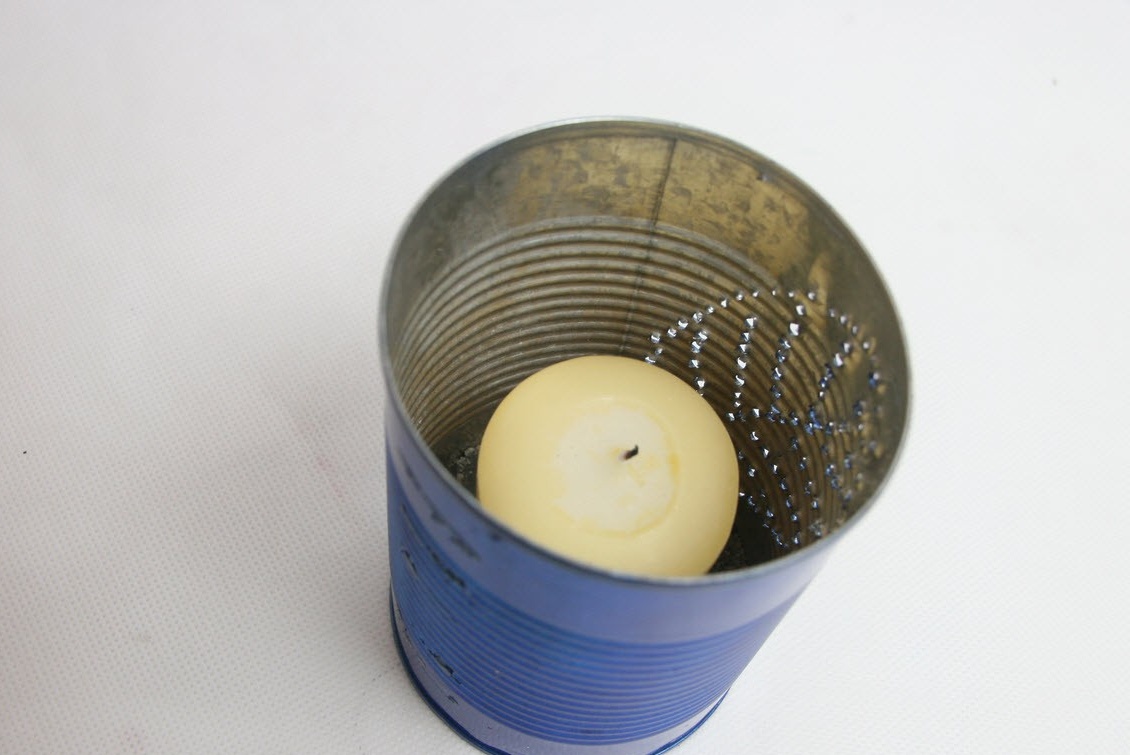 Umiestnite sviečku do stredu plechovky
