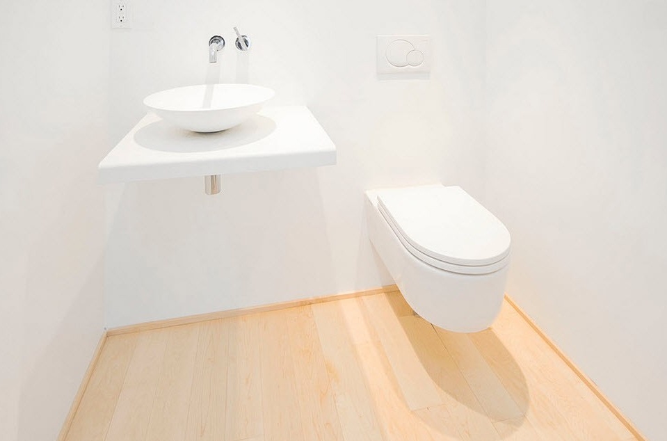 Λευκός νιπτήρας σε μια βάση δίπλα στην τουαλέτα