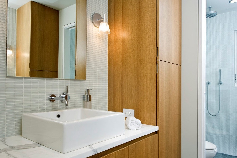 White washbasin next to a wooden cabinet