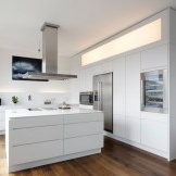 La combinazione di cucina bianca con pavimento in legno