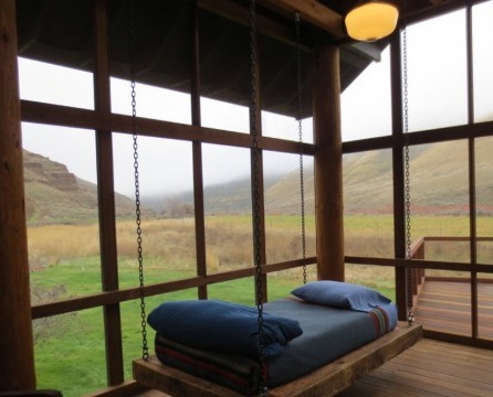 Závěsná postel s modrým závojem na verandě
