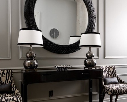 Spegel i en rund svart ram och två vita lampor