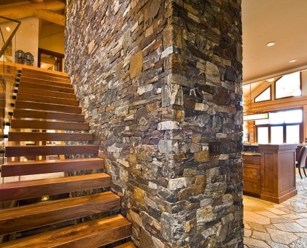 Escalier en bois contre un mur de pierre