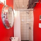 Fotoattēlā sarkana maza vannas istaba