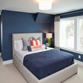 Zilas un oranžas krāsas kombinācija guļamistabas interjerā