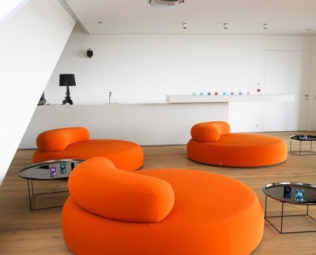 Rodinný relaxační prostor s jasně oranžovým kulatým nábytkem