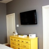 Yellow dresser in an olive bedroom