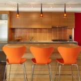 Oranžie krēsli kā akcents virtuves interjerā
