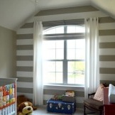 Jedna stena detskej izby je zdobená širokými vodorovnými pruhmi