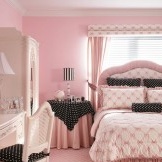 Interior de um quarto rosa claro com a introdução do preto como acessórios
