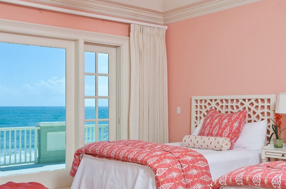 Chambre rose avec grande fenêtre.