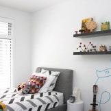 غرفة داخلية بيضاء لصبي مخفف بإكسسوارات ملونة