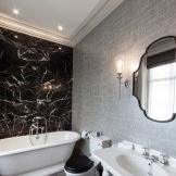 Upeat sisätilat mustavalkoisesta kylpyhuoneesta, jonka seinillä harmaa taustakuva