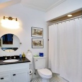 Sort og hvidt interiør i et lille badeværelse, hvor hovedtonen er hvid