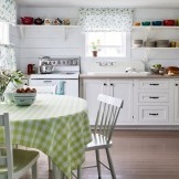 Como accesorios, platos de colores brillantes y un jarrón de flores en el interior de una cocina rústica.