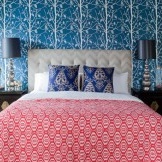 Tapet i sovrummet ekar med dekorativa kuddar på sängen