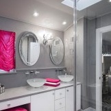 Home brillant i atractiu de color rosa brillant en el fons de parets grises neutres. Interior elegant del bany