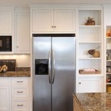 Geladeira integrada em móveis de cozinha economiza espaço em uma pequena cozinha