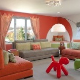 Dzīvojamās istabas rotājums oranžos toņos.