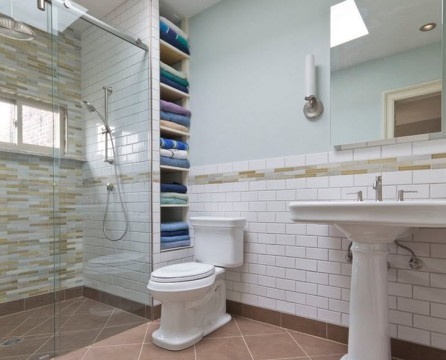 Πολλές πετσέτες στα ράφια δίπλα στην τουαλέτα