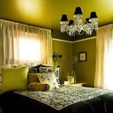 Zielonkawe światło z żyrandola w sypialni