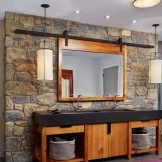 El área del lavabo y el espejo se destaca con un gran acabado de piedra.