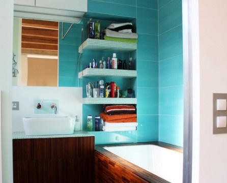 Mur turquoise dans la salle de bain avec étagères