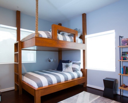 Poschodová posteľ s pruhovanou matracou medzi rohovými oknami