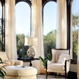 White upholstered furniture in front of panoramic windows
