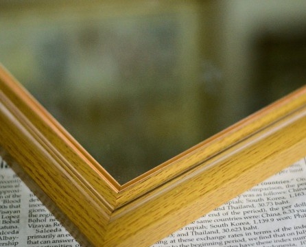Hoek van een houten frame voor een krantenspiegel
