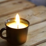 Lighted candle in a cup