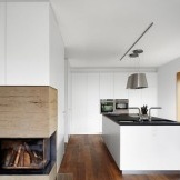 Kombinácia bielych fasád kuchynského nábytku s drevenými podlahami