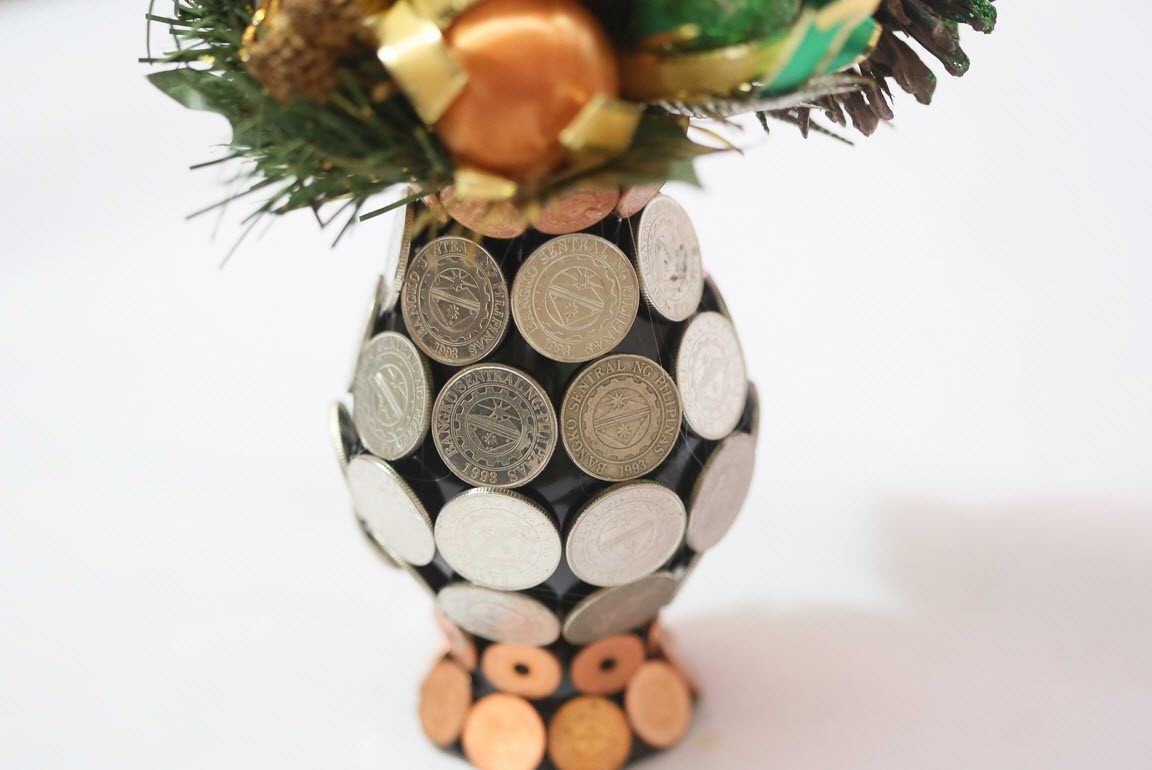Vase glued with coins, with a bouquet