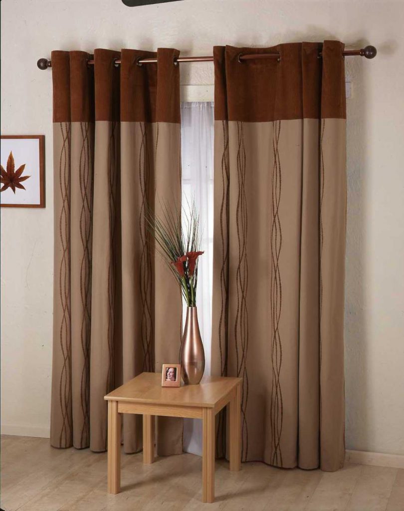 Monokrome brune gardiner på grommets i stueinteriøret