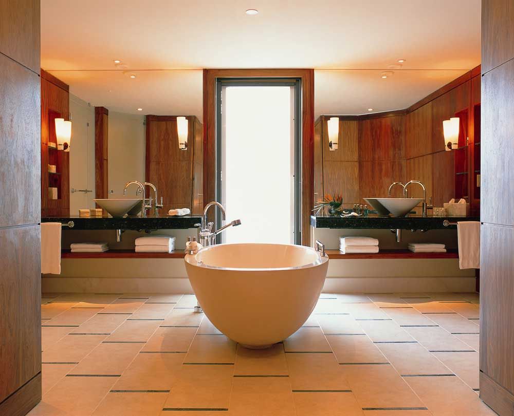 Ευρύχωρο μπάνιο με λάμπες τοίχου και μεγάλους καθρέφτες