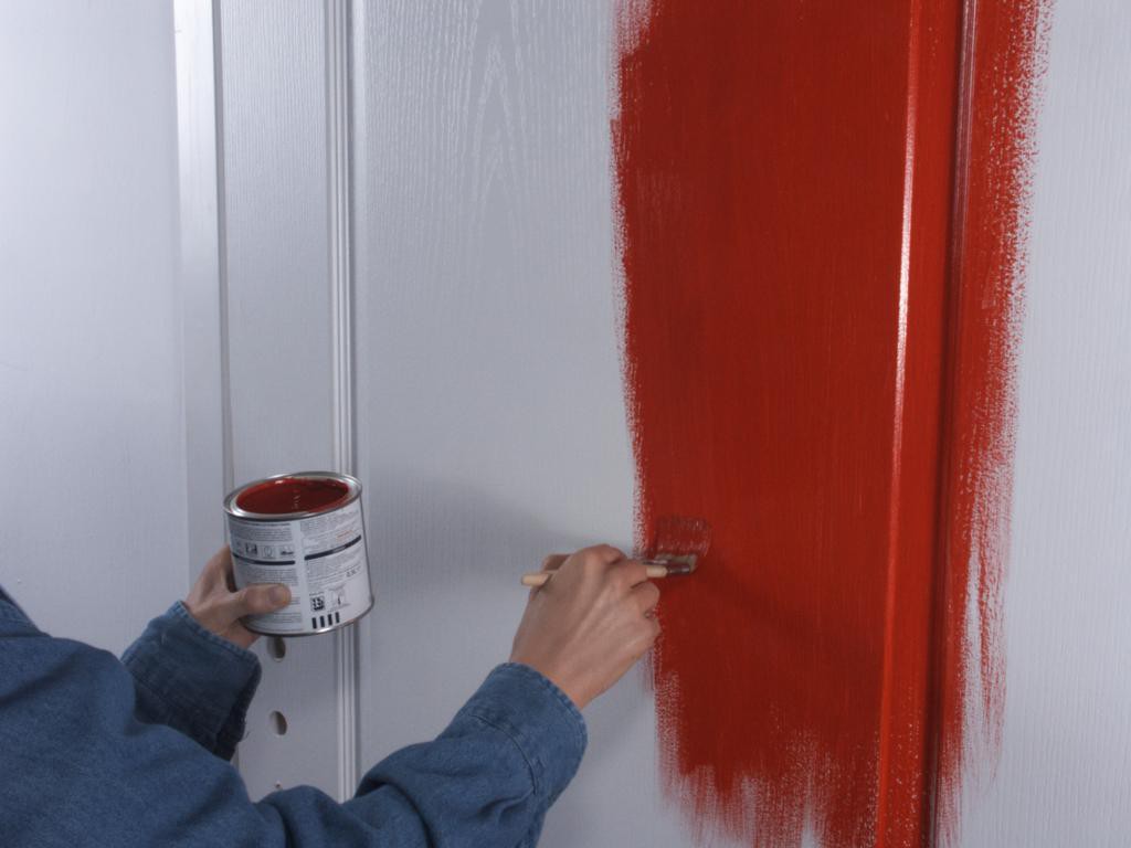 Ζωγραφίζοντας μια λευκή πόρτα με κόκκινο χρώμα