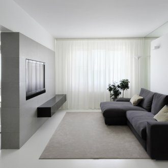 Minimalist bir yaşam alanında siyah kanepe