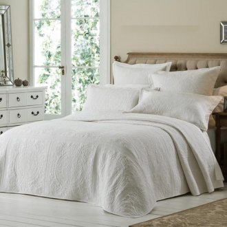 Colcha blanca en el diseño de la cama.