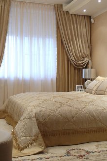 Colcha beige-oro en el diseño de la cama.