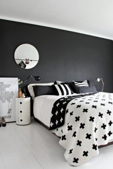 Black and white Scandinavian bedroom with a round mirror