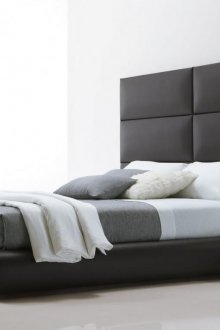 Katil hitam dengan kepala katil yang tinggi di dalam bilik tidur dengan gaya minimalis