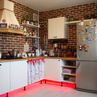 Brick walls and white and brown kitchen furniture in a country style