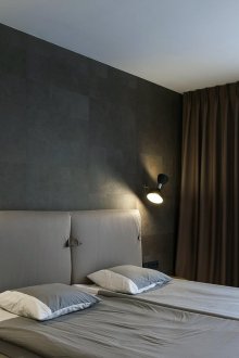Μαύρος τοίχος σε ένα λευκό και γκρίζο υπνοδωμάτιο