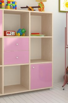 Bibliothèque rose-beige avec tiroirs dans la chambre d'enfant