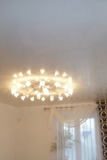 Um pequeno lustre com teto branco na sala de estar