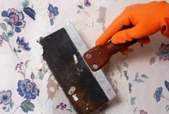 Le processus de retrait du vieux papier peint avec une spatule